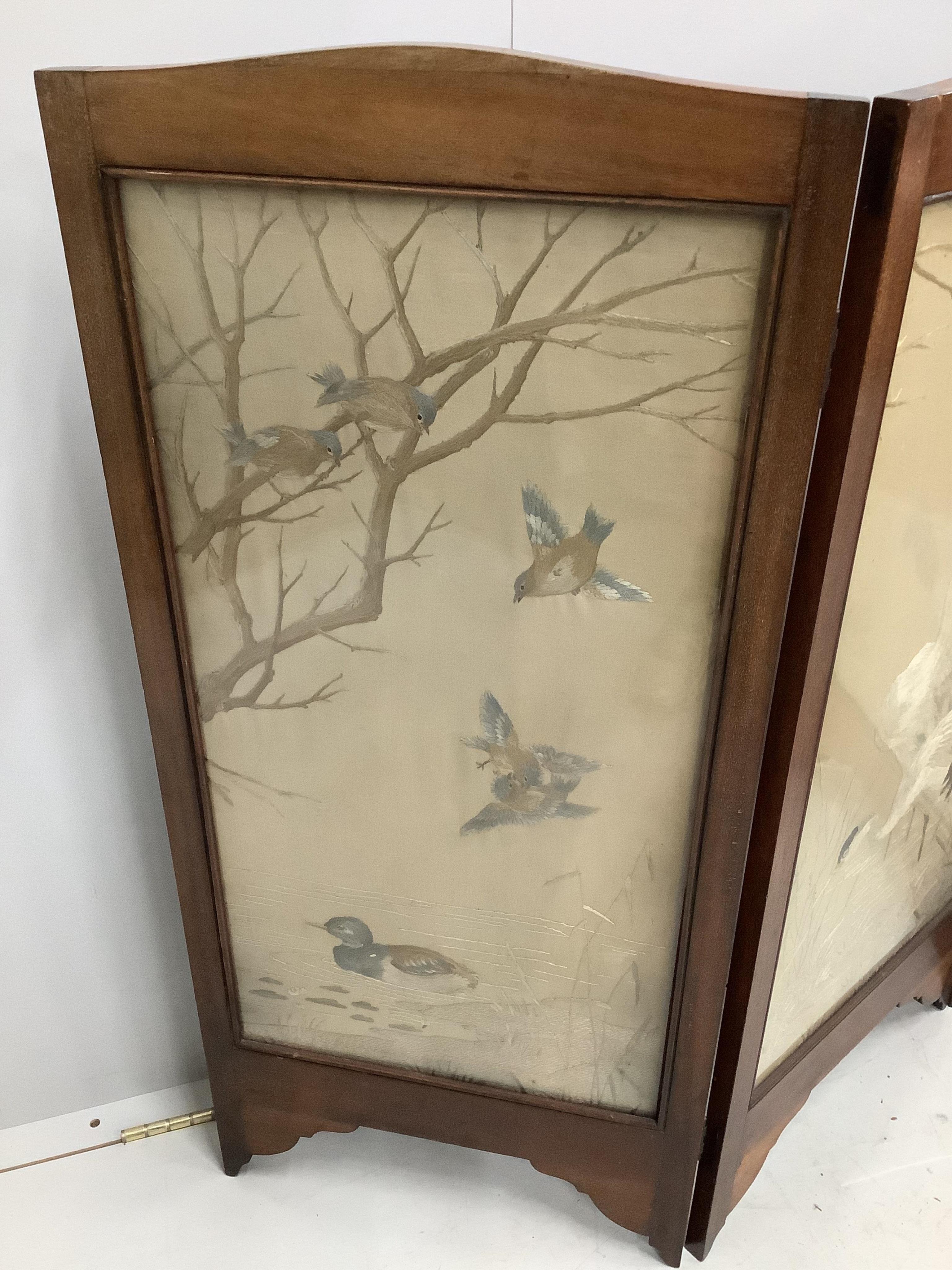 An early 20th century silk thread embroidered four fold table screen, decorated with birds among reeds, each panel width 41cm, height 94cm. Condition - fair